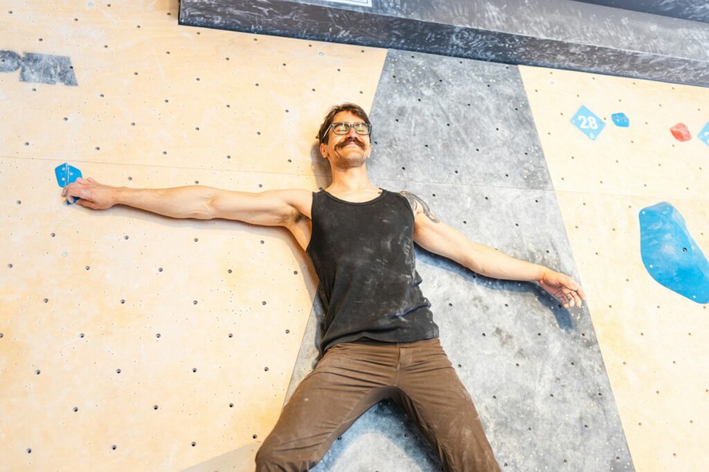 Man bouldering on a colourful indoor climbing wall