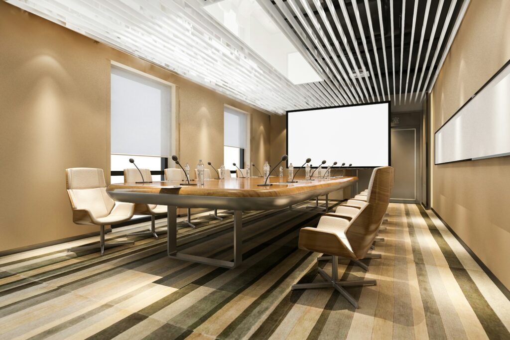 Modern conference room with a long table and chairs, fitted with integrated AV equipment