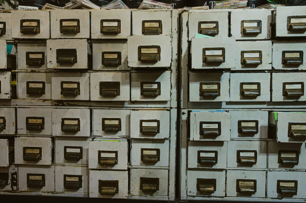 Rows of old filing cabinets with labels, representing organised business records kept for compliance
