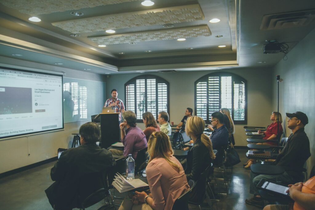 Group of people in a room facing a projector screen during a team training session