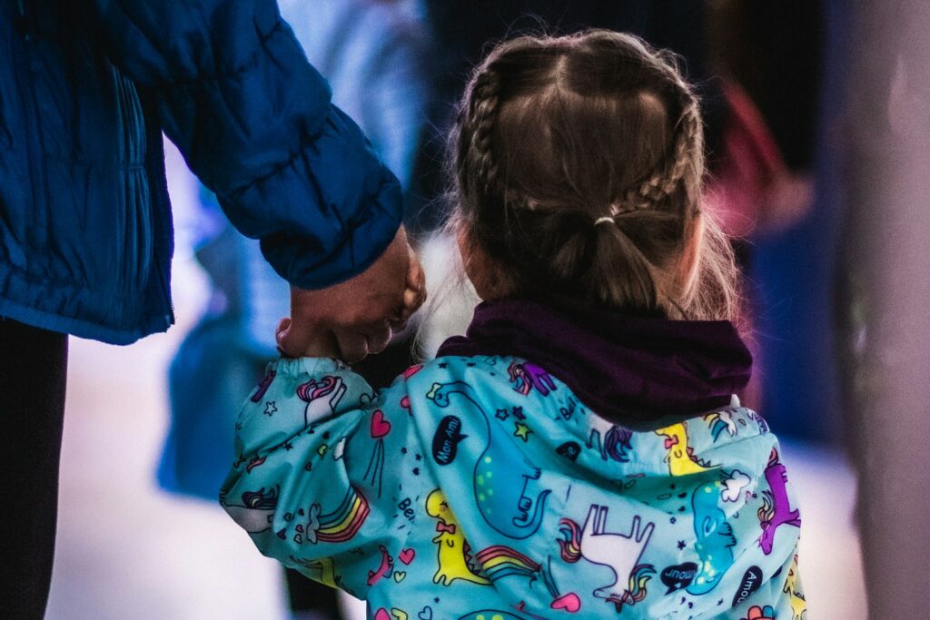 Little girl holding an adult's hand, reflecting the trust built in fostering and attachment