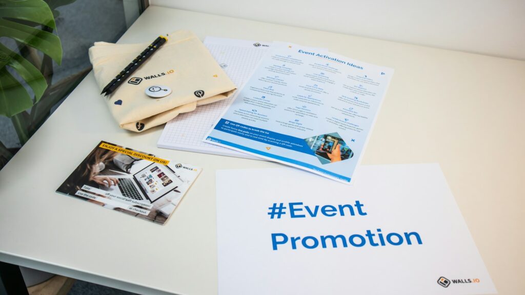 Table with a brochure, magazine and pen, showing printed leaflets alongside other promotional material